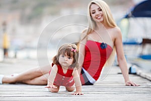Happy mother with a young daughter near Yacht Club