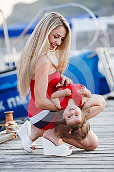 Happy mother with a young daughter near Yacht Club