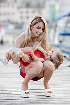 Happy mother with a young daughter near Yacht Club