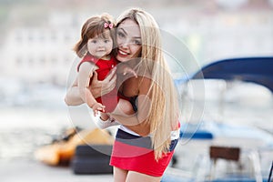 Happy mother with a young daughter near Yacht Club