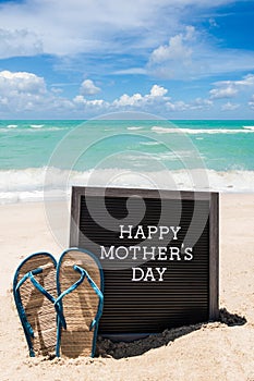 Happy Mothers day beach background with black board and flip flops