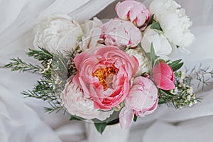 Happy Mothers day. Beautiful stylish peonies bouquet on background of soft white fabric