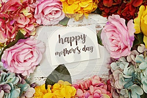 Happy Mothers day Card with colorful flowers border frame on wooden background