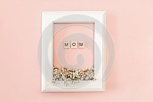Happy mothers day card - white frame with text and fresh spring flowers on pink background