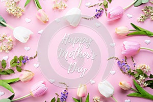 Happy mothers day concept. Top view of pink tulip flowers in frame with happy mother`s day text on pink pastel background. Flat