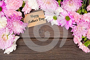 Happy Mothers Day gift tag with arch border of flowers over a dark wood background