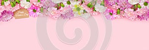 Happy Mothers Day gift tag with long top border of flowers on a pink banner background