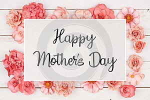 Happy Mothers Day greeting card with frame of pink paper flowers over white wood