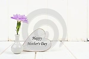 Happy Mothers Day heart tag with carnation against white wood