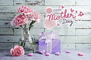Happy mothers day message on wood background and pink carnation