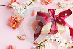 Happy Mothers day. Stylish gift box with flowers on pink background composition. Greeting card template. Craft gift with ribbon,