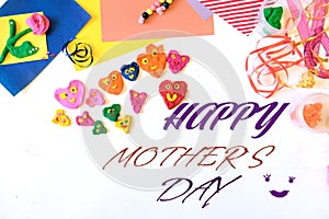 Happy Mothers Day text. Child made many funny hearts with smiles and flower. Hearts from colorful plasticine, Kid craft