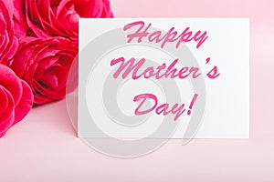 Happy Mothers Day text on gift card in flower bouquet of pink roses on pink background. Greeting card for Mom. Flower delivery,