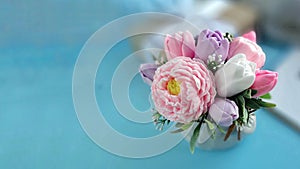 Bouquet of soap flowers on blurred blue background