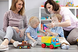 Group of happy moms with their babies in nursery