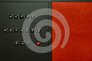 Happy motherâ€™s day greetings on blackboard decorated with red heart