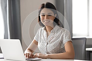 Happy motivated asian female employee working with computer portrait. photo