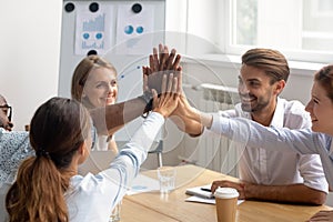 Happy motivated diverse members of business team join hands together photo