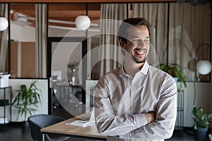 Happy motivated young hispanic businessman posing in modern office.