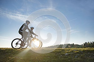 Happy mountainbike couple outdoors have fun together on a summer afternoon