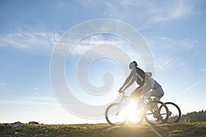 Happy mountainbike couple outdoors have fun together on a summer afternoon