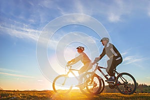 Happy mountainbike couple outdoors have fun together on a summer afternoon sunset