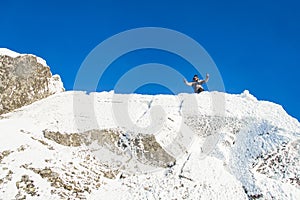 Happy The mountaineer climbed the mountain top covered with ice and snow, man hiker celebrating success at the peak of