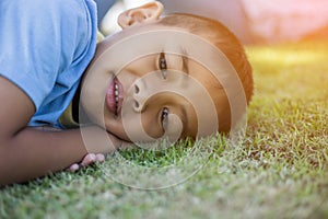 Happy mulatto boy child is smiling enjoying adopted life. Portrait of young boy in nature, park or outdoors. Concept of happy