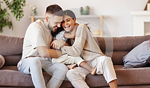 Happy multi ethnic family mother father and son having fun at home on couch