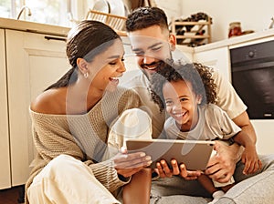 Happy multi ethnic family: parents and son laughed and watch funny video on a tablet  at home photo