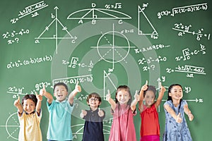 Multi-ethnic group of school children standing in classroom with math concept photo