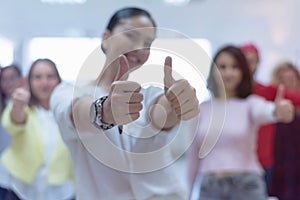 Happy multi ethnic students group showing thumbs up, smiling diverse young people looking at camera with like gesture recommend