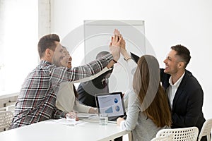 Happy multi-ethnic team giving high-five together promising loya