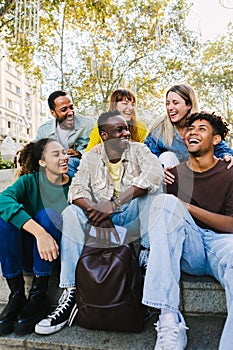 Happy multi-ethnic young diverse hipster student friends hanging out outdoors.