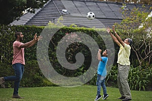 Happy multi-generation family playing with soccer ball at park