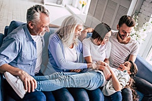 The happy multi generation family sitting on the sofa.