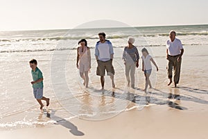 Happy multi-generation family walking and having fun on beach