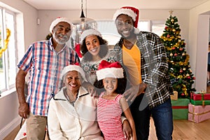 Happy multi generation family wearing santa hats, taking photo