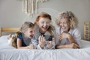 Happy multi-generational family watch funny videos on smartphone