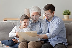 Happy multi generational men having fun using laptop at home
