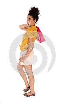 A happy multi-racial woman with one shopping bag over her shoulder