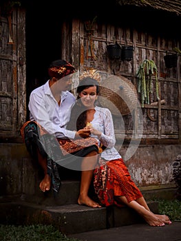 Happy multicultural couple. Romantic concept. Couple in love. Bamboo house. Caucasian wife and Balinese husband wearing