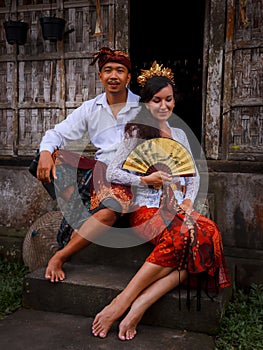 Happy multicultural couple. Romantic concept. Couple in love. Bamboo house. Caucasian wife and Balinese husband wearing