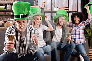 happy multicultural friends celebrating patricks day with beer photo