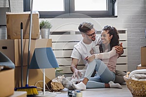 Happy multiethnic couple just moved into new empty apartment unpacking