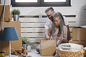 Happy multiethnic couple just moved into new empty apartment unpacking