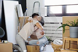 Happy multiethnic couple just moved into new empty apartment unpacking