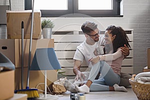 Happy multiethnic couple just moved into new empty apartment unpacking