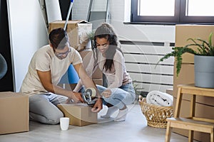 Happy multiethnic couple just moved into new empty apartment unpacking