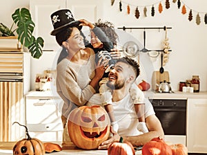 Happy multiethnic family mom, dad and son have fun and celebrate Halloween at home